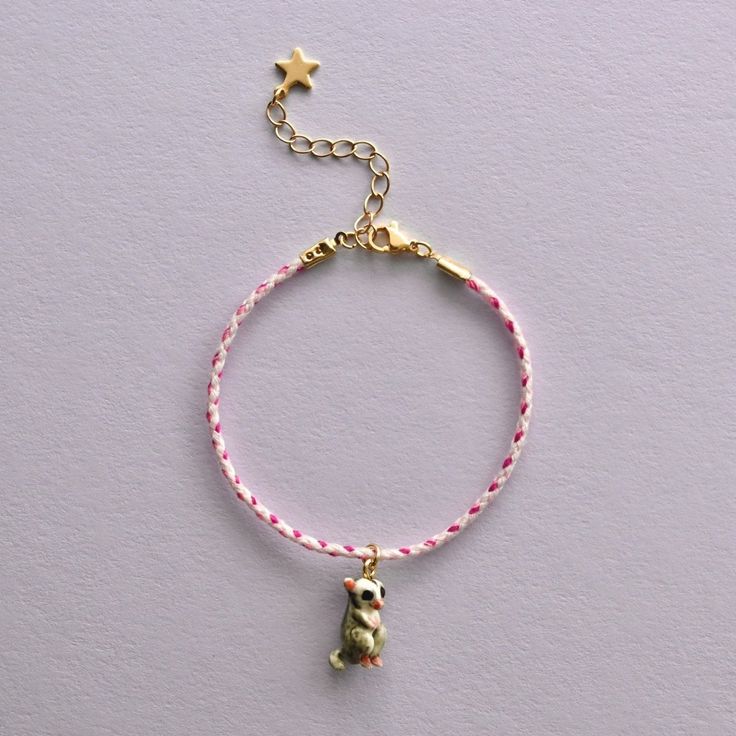 a bracelet with a teddy bear on it and a star charm hanging from the end