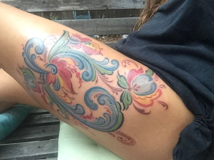 a woman's thigh with colorful tattoos on it