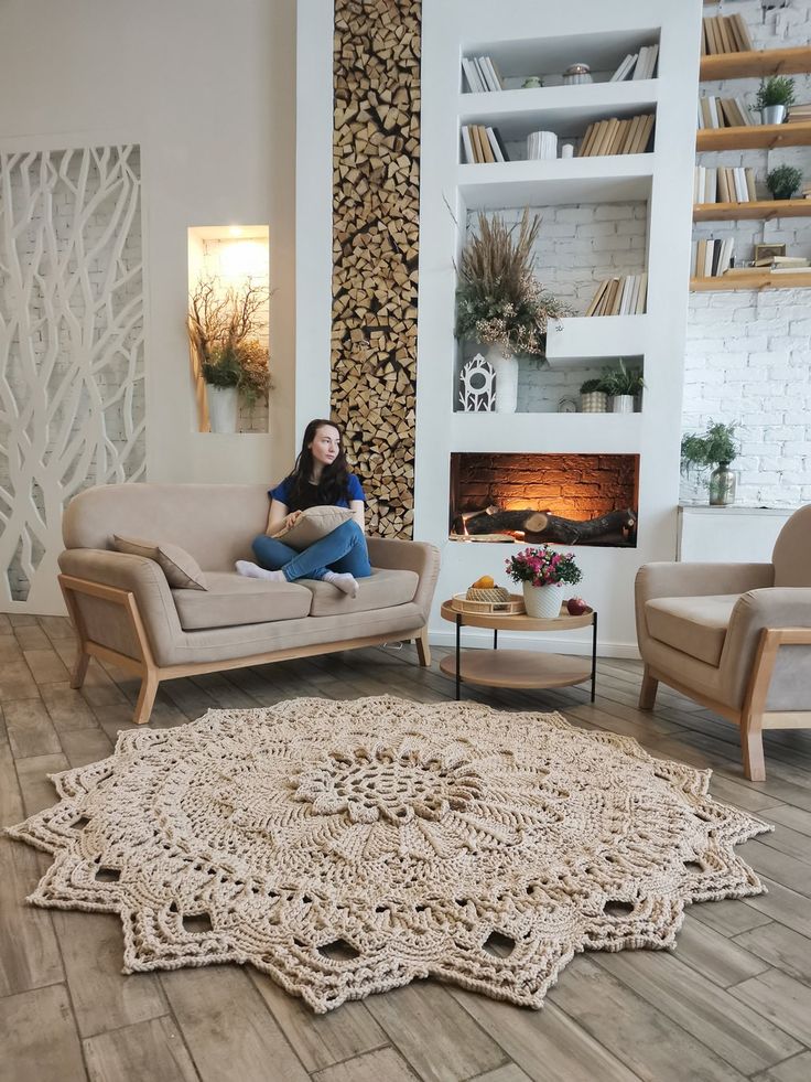 a woman sitting on a couch in front of a fire place with bookshelves