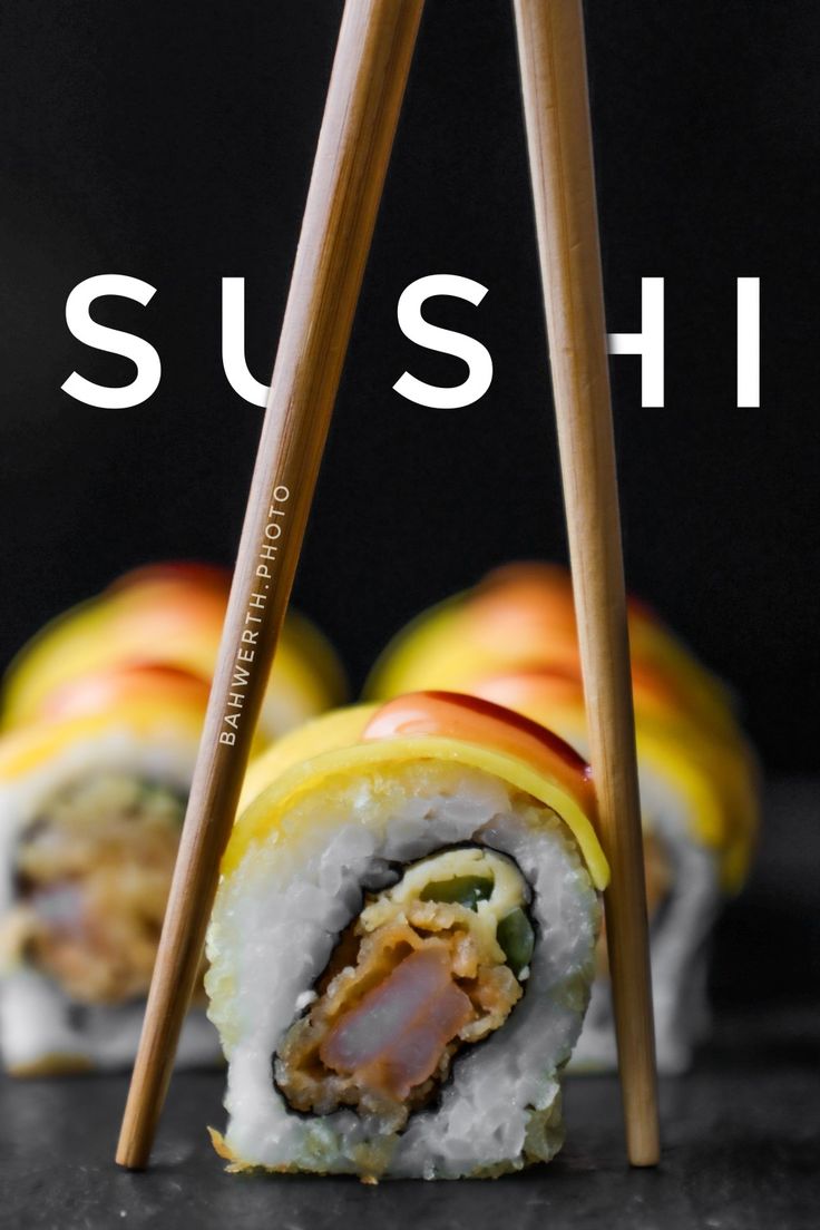 sushi with chopsticks sitting on top of it and the words sushi written in white