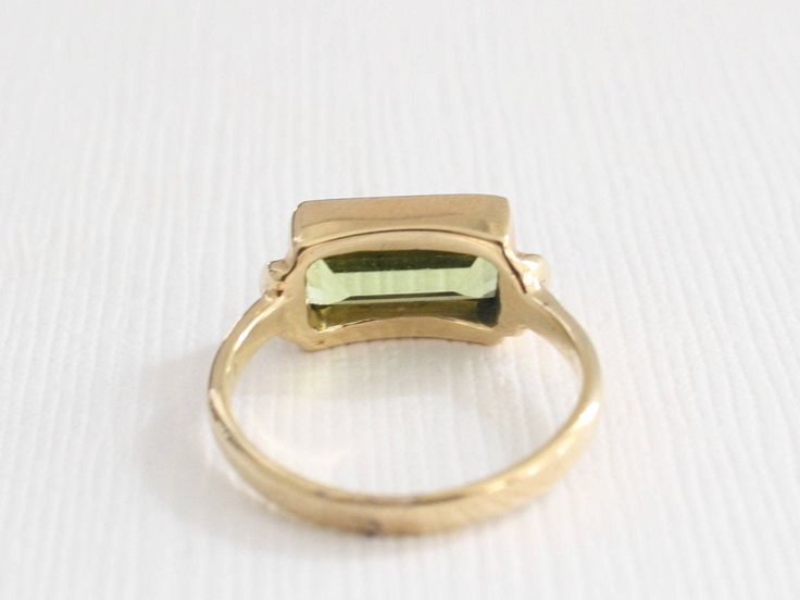 SOLID 14 karat yellow gold solitaire ring set with 1 rectangular cut natural peridot measuring 10 x 5 mm (approximately 2.00 carats). Available in all ring sizes. Also available in 14K rose or white gold, and 18K (all metal colors). Please email us with any custom request. The finish can be customized to matte or hammered. Made to order. SKU 8-100292 Elegant Green Rectangular Signet Ring, Green Rectangular Signet Ring For Formal Occasions, Rectangular Gold Emerald Ring With Bezel Setting, Hallmarked Rectangular Emerald Ring, Rectangular Yellow Gold Signet Ring With Gemstone, 14k Gold Green Rectangular Ring, Rectangular Green 14k Gold Ring, Green Rectangular 14k Gold Ring, Elegant Rectangular Peridot Rings