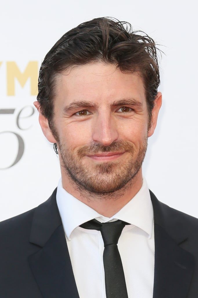 a man in a suit and tie smiling at the camera