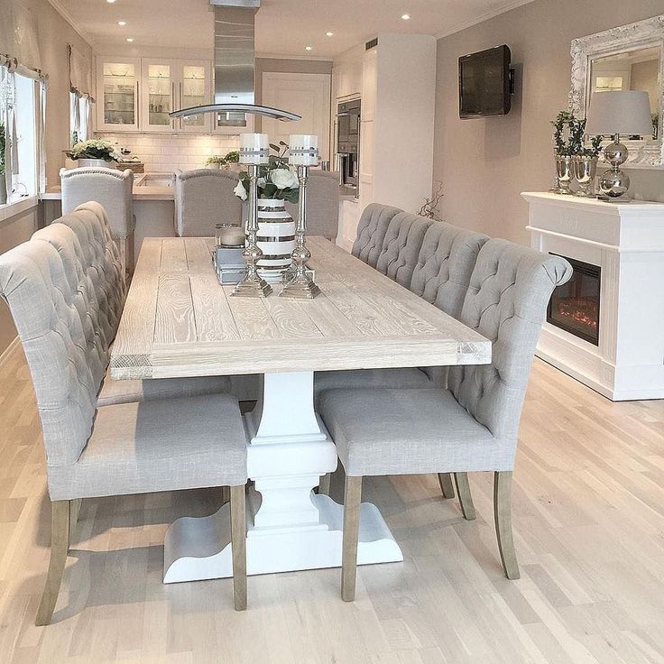 a dining room table with chairs around it and a fireplace in the backround