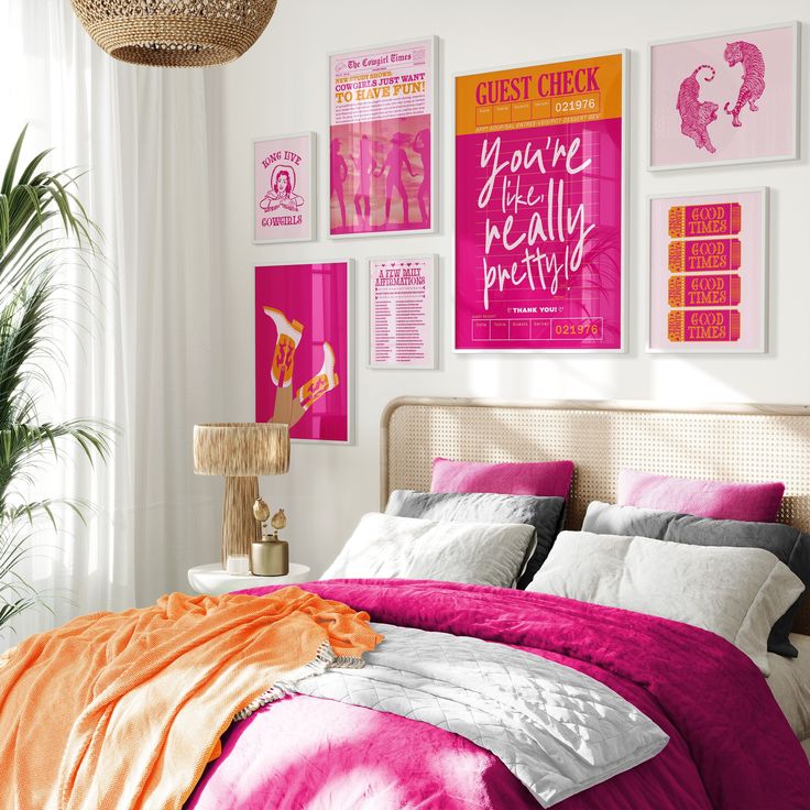 a bedroom with pink, orange and white decor on the wall above the bed is decorated with posters