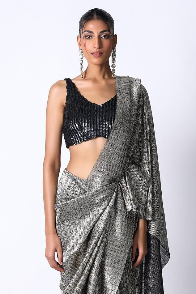 Charcoal and black pre draped metallic saree in a pleated base. Comes with sequin embellished blouse.
Components: 2
Pattern: Textured,Embellished
Type Of Work: Sequin
Neckline: V-neck
Sleeve Type: Sleeveless
Fabric: Silk,Pleated Metallic
Color: Black,Grey
Other Details: 
Built in petticoat
Closure: Saree: Front button
Occasion: Cocktail,Reception - Aza Fashions Black Draped Blouse For Evening, Black V-neck Blouse For Party, Elegant Black Draped Blouse, Black Silk Evening Blouse Piece, Fitted Draped Blouse For Party, Draped Fitted Party Blouse, Fitted V-neck Pre-draped Saree, Elegant Party Saree With Sleeveless Blouse, Sleeveless Formal Pre-draped Saree