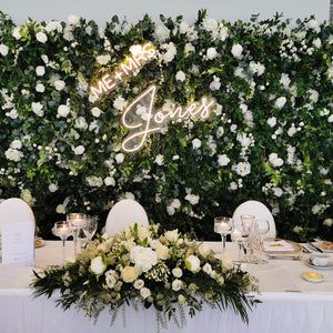 the table is set with white flowers and place settings