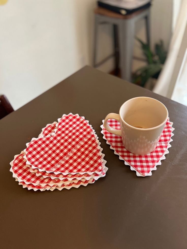 a cup and saucer sitting on top of a table next to two napkins