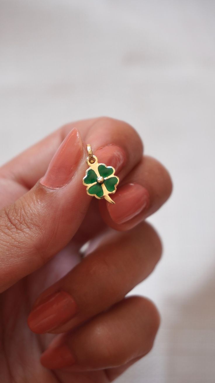 Introducing the delightful enamel 14k gold clover charm, perfect for adding a touch of sweetness to your jewelry collection! Handcrafted with love and attention to detail, this charming piece features a vibrant green enamel finish, nestled on a gleaming 14k gold. The luscious enamel color pops against the shiny gold, creating a stunning contrast that will catch the eye of anyone who sees it. This four leaf clover charm is not only beautiful but also durable, thanks to its high-quality materials and expert craftsmanship. It's made with solid 14k gold, which is known for its durability and resistance to tarnishing, so you can wear it with confidence for years to come. This enamel 14k gold clover charm is sure to delight. It makes a thoughtful and charming gift for yourself or someone special Clover Charm, Luck Charm, Enamel Necklaces, Luck Charms, Green Enamel, Four Leaf, Vibrant Green, Leaf Clover, Charm Gift