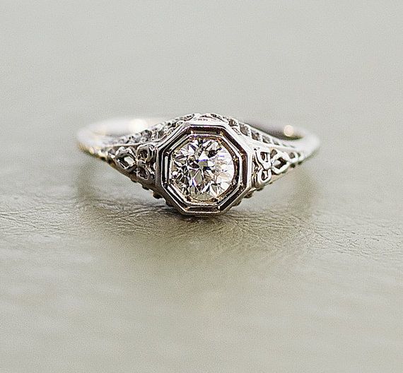 an antique style diamond ring with filigree details