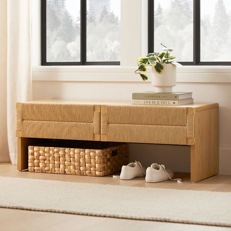 a pair of shoes under a bench in front of a window with a basket underneath it