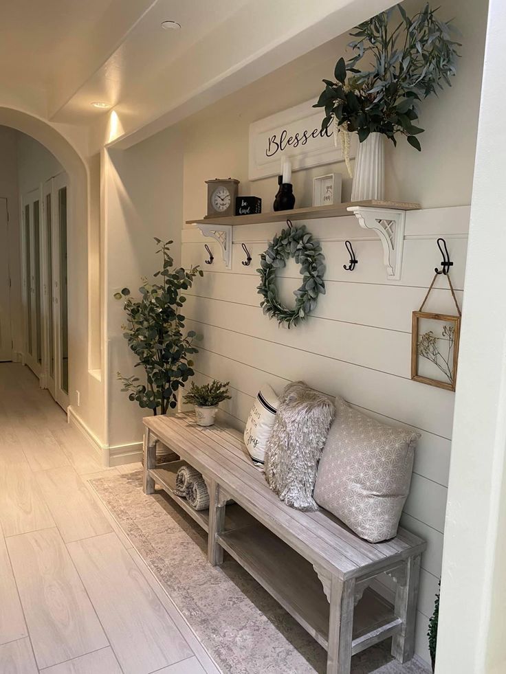 the entryway is decorated with wreaths, plants and other decorating items on shelves