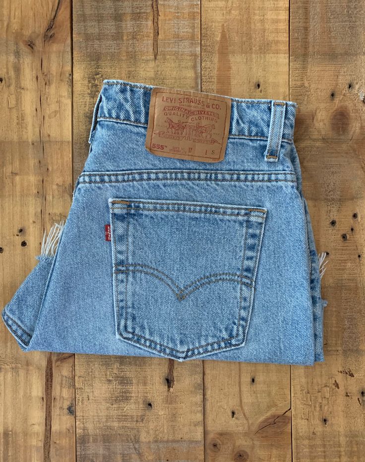 "High waisted 90's denim shorts. Made by Levi's Jeans in light blue denim wash. Shorts are in excellent clean condition. Perfectly worn in with light naturally distressed character and handmade wear holes. These have been cut off and washed once. Measurements are taken zipped or buttoned up and laid comfortably flat then x 2 for total circumference (inches) Tag Size 13 Levis 555 100% Cotton Made in USA Waist 34\" Hips 46\" Length 14\" Inseam 3\" Rise 12\" leg opening circumference 26\" All items Retro Straight Leg Jean Shorts With Pockets, 90s Distressed Cutoff Bottoms, Vintage Distressed Medium Wash Shorts, 90s Cutoff Jeans With Pockets, Vintage Medium Wash Straight Leg Shorts, Vintage Light Wash Mid-rise Shorts, Vintage Cutoff Jean Shorts In Medium Wash, Vintage Medium Wash Cutoff Jean Shorts, Vintage Medium Wash Jean Shorts With Frayed Hem