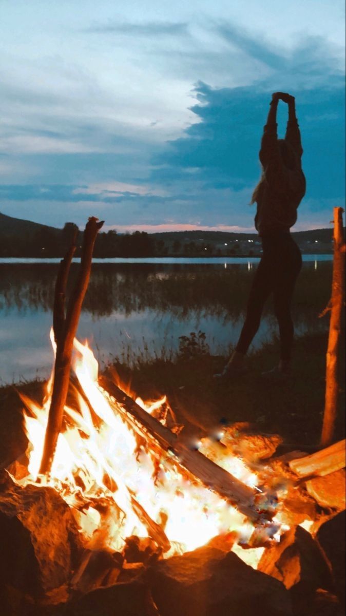 a person standing in front of a campfire