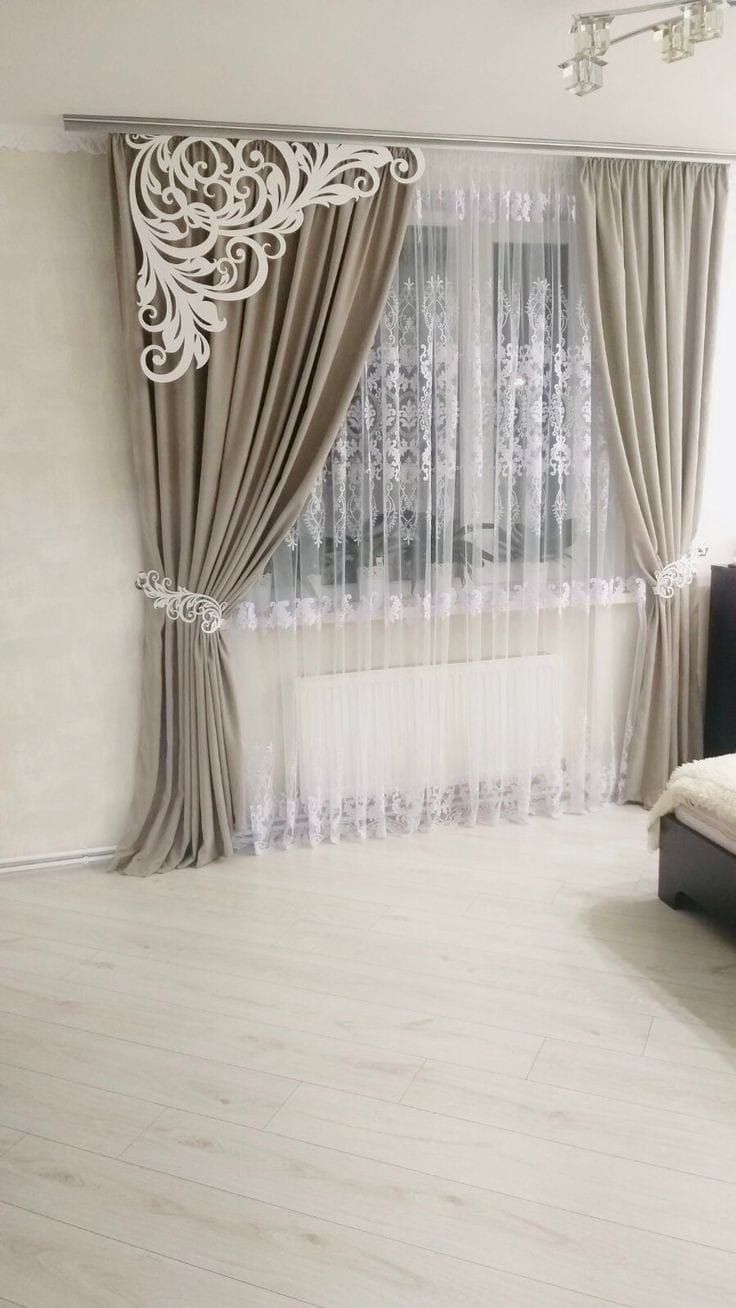 a bedroom with white walls and curtains on the windowsill