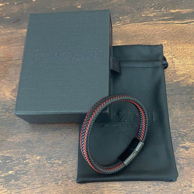 Handcrafted from premium leather Astro is an elegant bracelet, as tough as it looks. Red leather strips weave up and down the wide band, adding a dash of spark. With a minimalistic magnetized stainless steel clasp in black rhodium, it stacks effortlessly with other bracelets and watches, but is substantial enough to hold its own. Premium Nappa Leather Stainless Steel Clasp with Rhodium Bracelet, 10mm Wide Modern Black Leather Bracelet With Stainless Steel Clasp, Modern Black Leather Bracelet For Everyday Use, Modern Black Leather Bracelet For Everyday, Black Luxury Leather Bracelet For Everyday, Modern Braided Bracelets With Stainless Steel Clasp For Everyday, Modern Everyday Braided Bracelet With Stainless Steel Clasp, Black Rectangular Leather Strap Bracelet, Modern Leather Braided Bracelet With Black Band, Black Leather Braided Bracelet With Stainless Steel Clasp