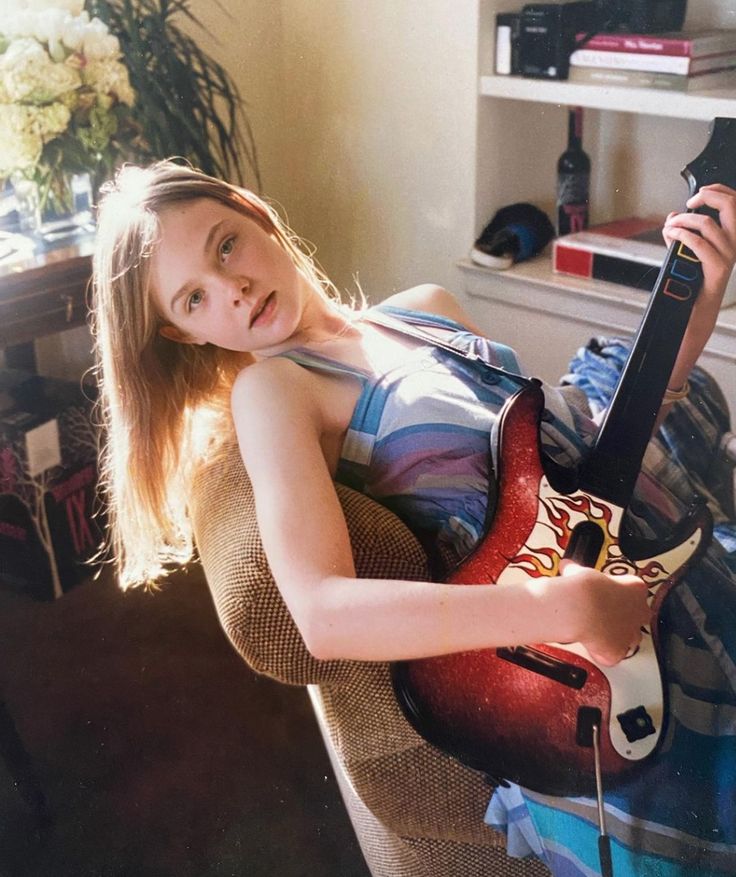 a girl is holding a guitar and smiling