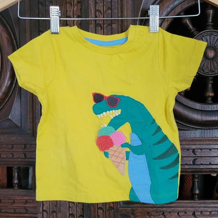 Sunny Yellow Graphic T-Shirt With An Applique Of A Dinosaur In Sunglasses Eating Icecream. New In Original Packaging, Didn't Come With Tags. Smoke Free Home. Summer Cartoon Print Top For Playwear, Cartoon Print Tops For Summer Playwear, Fun Yellow Summer Top, Casual Dinosaur Print T-shirt For Summer, Casual Summer T-shirt With Dinosaur Print, Green Dinosaur Print Top For Spring, Green Dinosaur Print Tops For Spring, Playful Dinosaur Print Tops For Summer, Playful Dinosaur Print Summer Tops