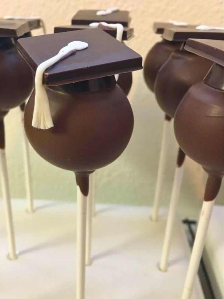 chocolate graduation cake pops are lined up in the shape of hats and tassels