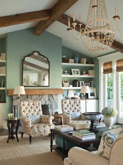 a living room filled with lots of furniture and a chandelier hanging from the ceiling