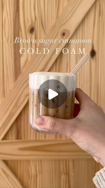 a person holding a cup with liquid in it and the words, brown sugar cinnamon cold foam