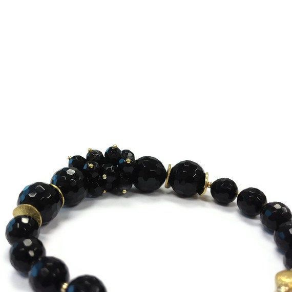 This black onyx bracelet created by Jewelry By CARMAL is made of black onyx faceted gemstones, vermeil beads, 14k gold filled: chain, findings and spring ring clasp closure. The bracelet measures 7 1/2 inches in length. View more beaded bracelets: http://www.etsy.com/shop/jewelrybycarmal?section_id=8002918 WE OFFER FREE STANDARD SHIPPING WITHIN THE UNITED STATES. All of our jewelry is unique and custom designed. We would love to assist you with any custom orders or needs for special occasions! W Black Stretch Bracelet With Faceted Round Beads, Black Bracelets With Faceted Round Beads, Black Beaded Agate Jewelry, Agate Bracelet With Faceted Beads, Elegant Natural Stone Bracelets For Parties, Elegant Onyx Beaded Bracelets With Black Beads, Black Agate Jewelry With Black Beads, Black Adjustable Rondelle Beaded Bracelets, Elegant Gemstone Beads Bracelets For Party