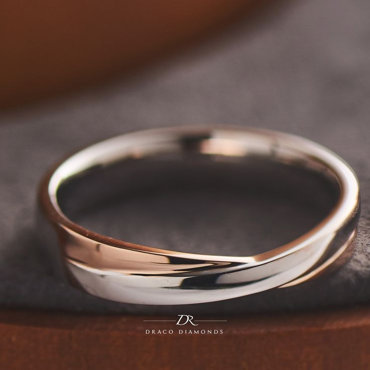 two wedding rings sitting on top of a table