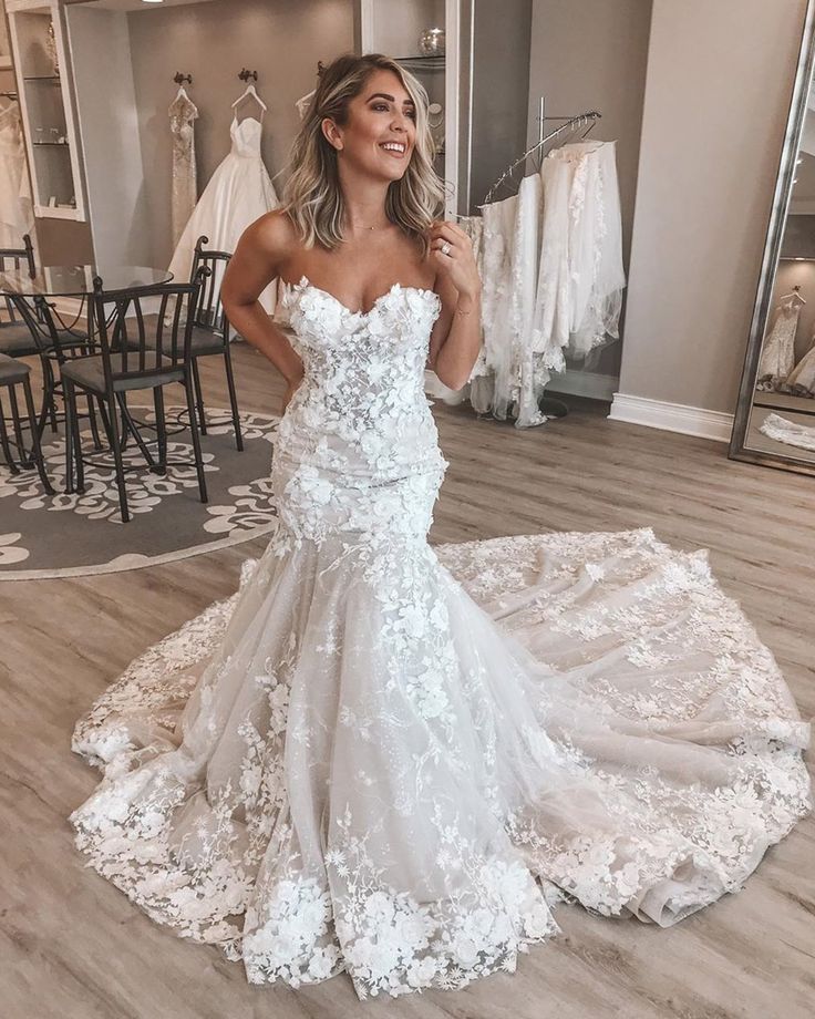 a woman standing in front of a wedding dress