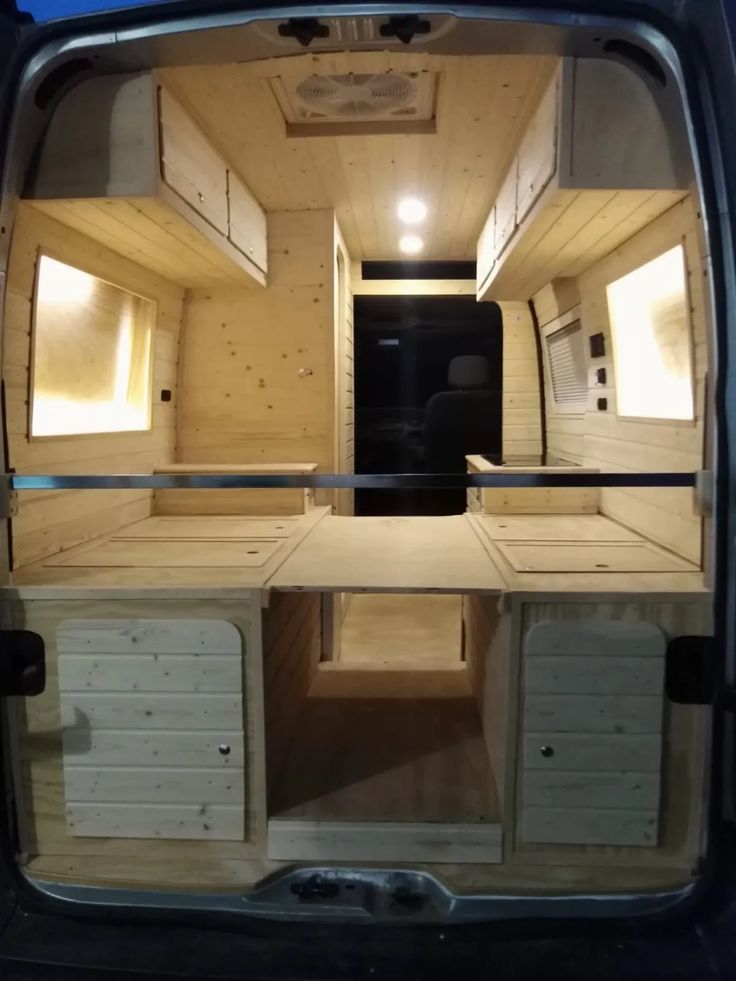 the inside of a van with no doors and shelves in it's back door