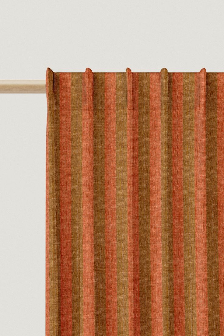 an orange and brown striped curtain hanging from a window