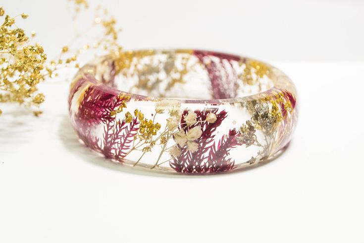 "Stunning real flower bracelet featuring red pine, white, gold and silver Baby's Breath flowers. The tiny Baby's Breath flowers are a symbol of everlasting love, pureness and innocence. This bracelet makes a unique Christmas gift. The bracelet is handcrafted from start to finish, and it is made with crystal clear jeweler's grade resin that captures the beauty and details of each flower. This nature bracelet makes a unique and wonderful gift. Available in 3 different sizes: Small: diameter/openin Unique Red Bracelet For Gift, Unique Red Bracelet As Gift, Delicate Red Jewelry For Gift, Christmas Bangle Jewelry Gift, Red Nature-inspired Jewelry For Gifts, Nature-inspired Bracelet Jewelry As A Gift, Handmade Nature-inspired Bracelets As Gifts, Adjustable Jewelry With Natural Inclusions For Gifts, Handmade White Bracelet As Gift For Her