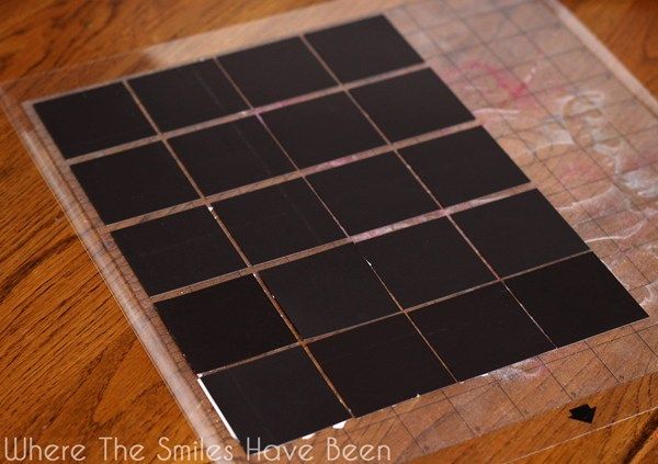 a piece of black tile sitting on top of a wooden floor