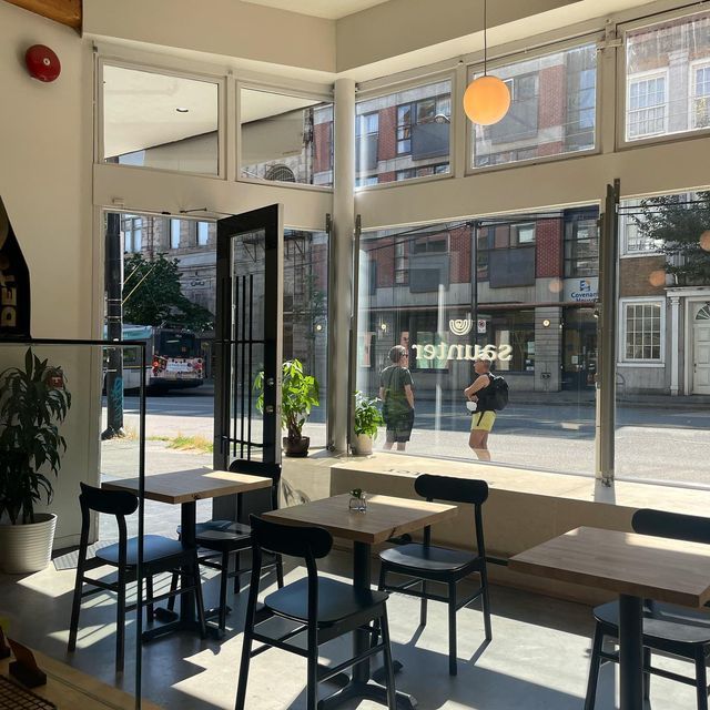 an empty restaurant with tables and chairs in front of large windows that look out onto the street