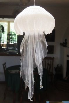 a white lamp hanging from a ceiling in a living room