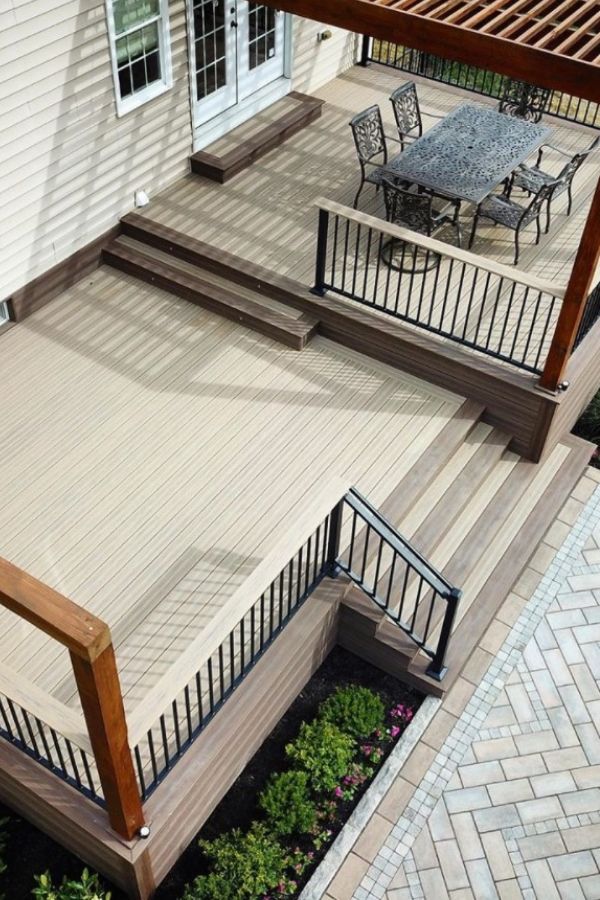 an outdoor patio with wooden steps and railings