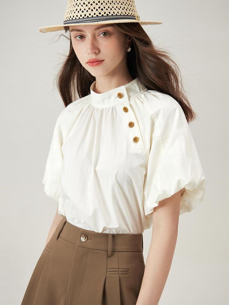 This is a casual and feminine top by We’Dee that is made out of high quality and sturdy material. With distinctive mood of the design and comfortable wear, you can style it for your unique daily outfit.- Puffy and short sleeves- Voluminous fit with shirring detail- Feminine and trendy mood White Short Sleeve Top With Button Cuffs, Short Sleeve Office Top With Button Closure, Office Tops With Button Closure And Short Sleeves, Short Sleeve Button Closure Office Tops, Versatile Cotton Tops With Button Closure, Versatile Cotton Tops With Buttons, Summer Puff Sleeve Tops With Button Cuffs, Modern Short Sleeve Tops With Button Cuffs, Chic Puff Sleeve Top With Buttons For Work