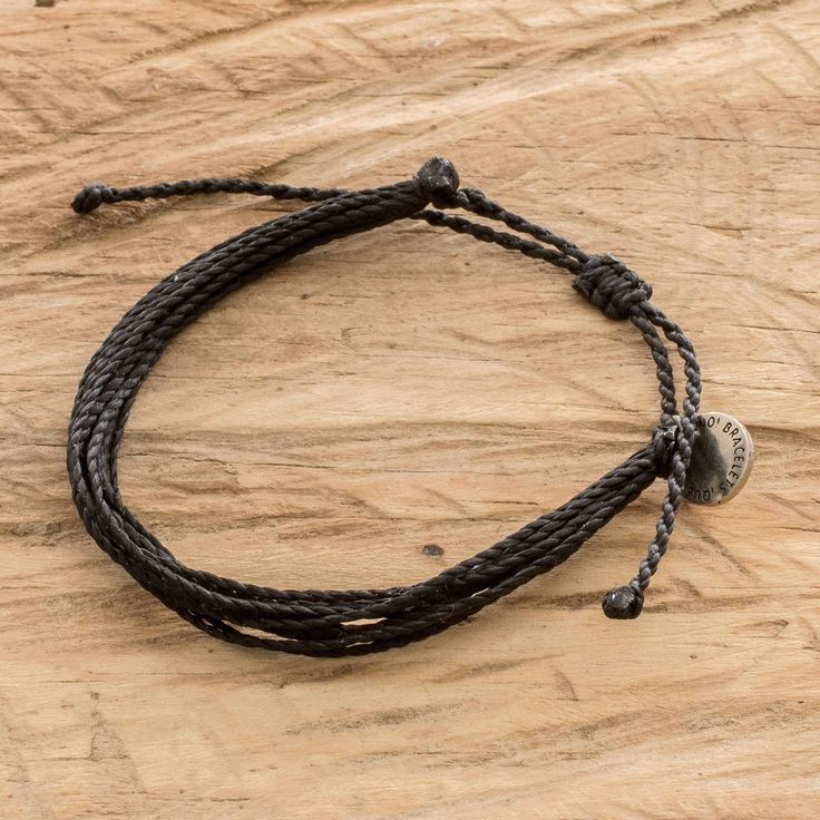 Nothing is as classic, timeless and versatile as black because it is the color that goes with everything and anything. Crafted by Victoria Zurdo in Guatemala, this adjustable cord wristband bracelet made of twelve black strands and featuring a metallic charm will definitely match any attire of your choice. Casual Braided Bracelets With Adjustable Length, Casual Braided Bracelet With Adjustable Cord, Casual Everyday Braided Bracelet With Adjustable Cord, Everyday Braided Bracelet With Sliding Knot, Casual Everyday Adjustable Jewelry, Adjustable Waxed Cord Bracelets For Everyday, Adjustable Nylon Cord Friendship Bracelet, Everyday Black Bracelets With Nylon Cord, Black Nylon Cord Braided Bracelet For Everyday