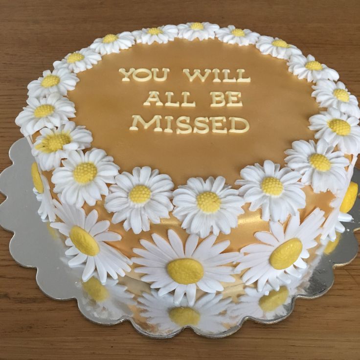 a cake decorated with daisies and the words you will all be missed