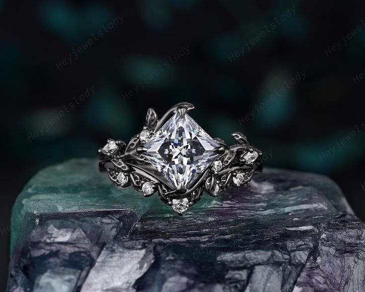 a diamond ring sitting on top of a crystal block with leaves and vines around it