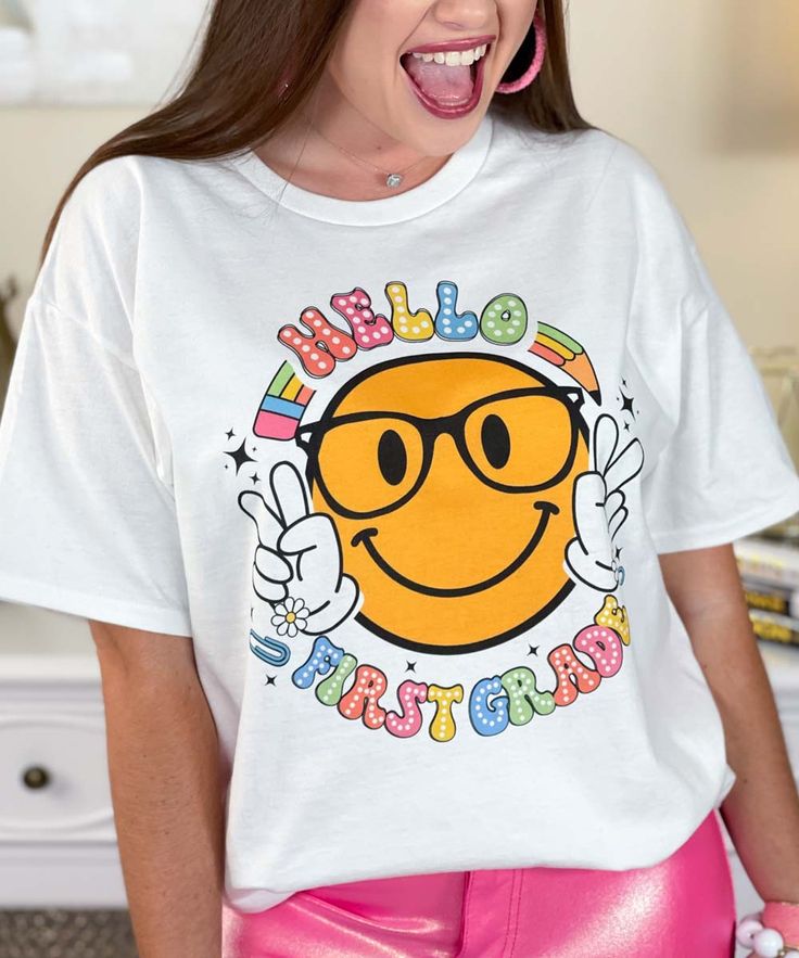 Introducing our "Hello Your Grade Smile Graphic Shirt," a cheerful and engaging addition to any teacher or student's wardrobe. Available in sizes YXS through 5XL, this shirt features a smiley face with the word "SMILE" above and "Your Grade" below, customizable from preschool to 5th grade, making it perfect for creating a positive and welcoming environment in the classroom.
Crafted from high-quality, soft materials, this shirt ensures all-day comfort, making it ideal for teachers greeting their new class or students starting a new school year. The "Hello Your Grade Smile Graphic Shirt" adds a fun and friendly touch to any outfit, encouraging smiles and positivity.
Celebrate the joy of learning and the start of a new school year with this versatile and comfortable graphic shirt. Whether you Playful White T-shirt With Smiley Face, Casual Relaxed Fit T-shirt For Back To School, Fun T-shirt With Funny Print For Back To School, Fun Cotton T-shirt With Smiley Face, Playful White Top With Smiley Face, Casual Tops With Funny Print For Teacher Appreciation, Casual Back To School Slogan T-shirt, Casual Slogan T-shirt For Back To School, White Playful T-shirt With Smiley Face