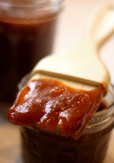 a spoon full of peanut butter and jelly on a table with jam in the background