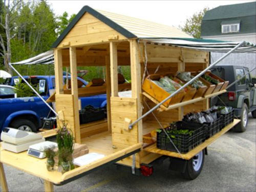 a small wooden trailer with lots of items on it