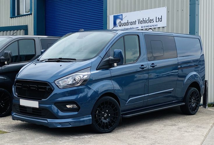 two blue vans parked in front of a building