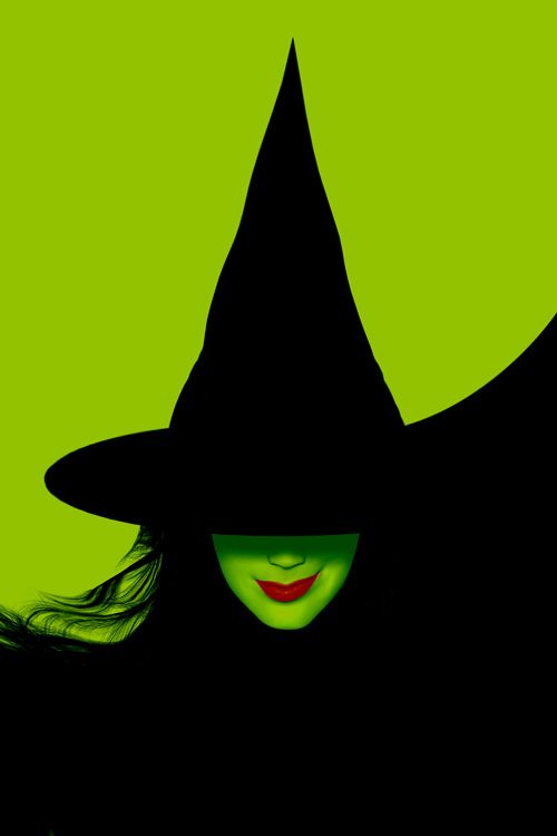 a woman wearing a witches hat and green eyes