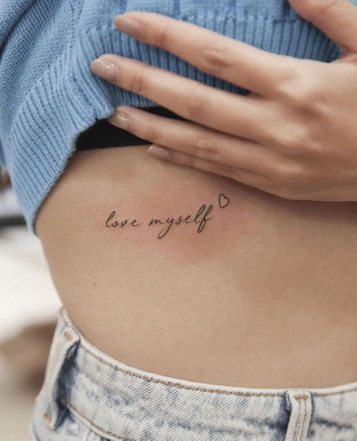 a woman's stomach with the words love my life tattooed on her lower back