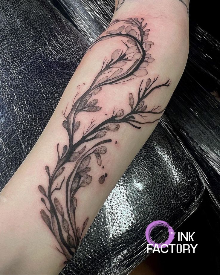 a woman's arm with flowers on it and the words ink factory written in black ink