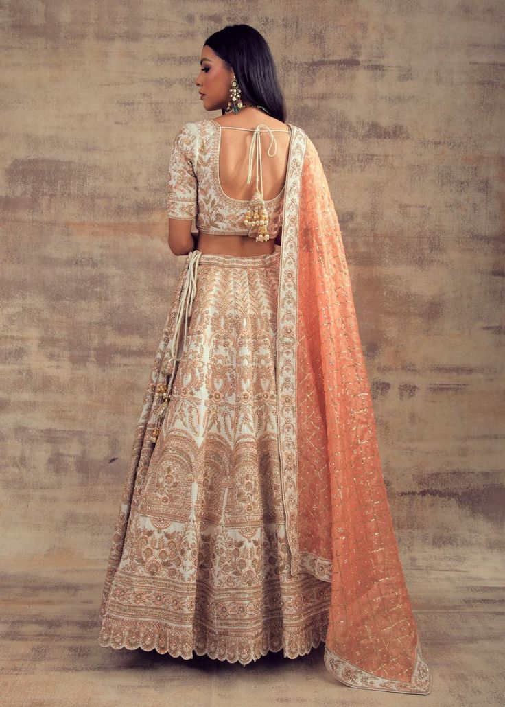 Pretty Yet Powerful Ivory Colored Lehenga for our Ladies! If you want to look gorgeous, feminine and powerful at the same time, then grab this pretty ivory-coloured lehenga. This lehenga is made up of raw silk fabric that speaks of femininity, freshness and boldness, that every woman wishes for. This lehenga is enriched with zardozi embroidery work, and also, it looks unique in its contrasting colours and patterns. It comes along with a blouse and banarasi tissue dupatta. This opulent lehenga wi Peacock Lehenga, Tissue Dupatta, Zardozi Embroidery, Curated Outfit, Raw Silk Fabric, Contrasting Colours, Indian Wedding Wear, Color Wedding, Indian Couture