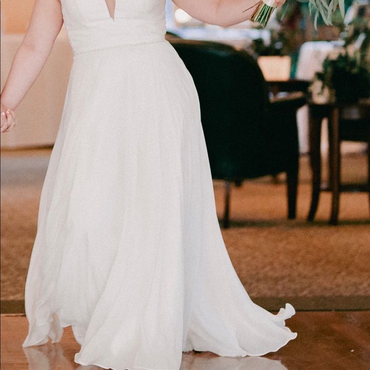 a woman in a white dress holding a bouquet of flowers