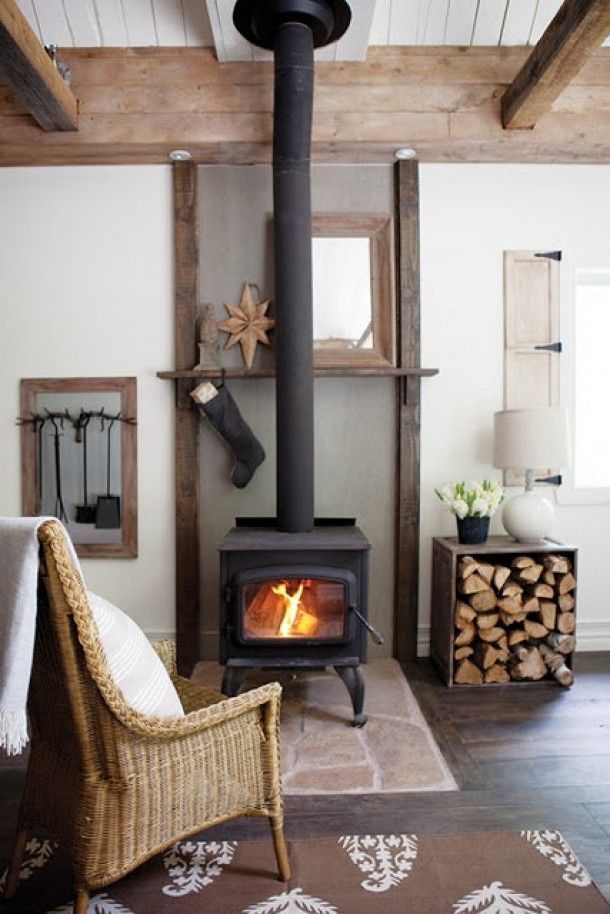 a living room filled with furniture and a fire place in the middle of it's fireplace