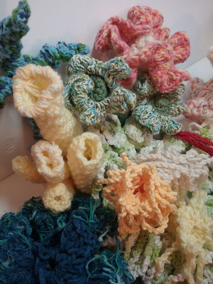 several crocheted flowers are laying next to each other