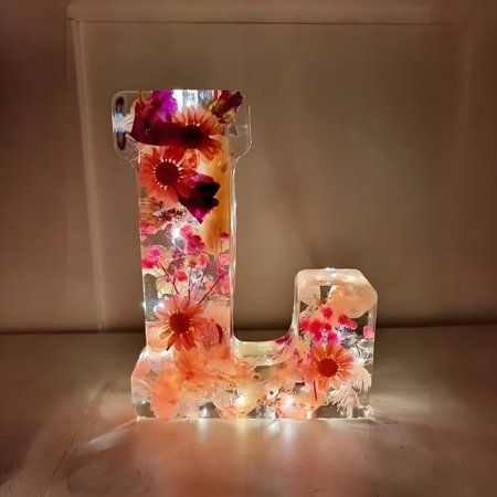 the letter j is made up of flowers and ice cubes with lights on it